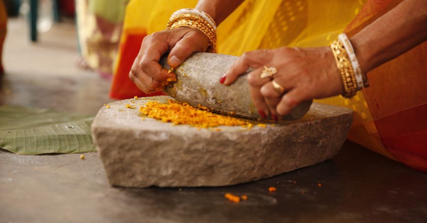 woman grinding turmeric powder